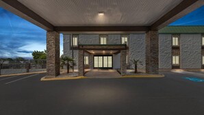 A building entrance with a covered walkway, stone pillars, and a glass door. - Quality Inn Hixson - Chattanooga (Hixson)
