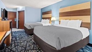 A hotel room with two beds, a desk, a chair, a TV, and a lamp. - Quality Inn Hixson - Chattanooga (Hixson)