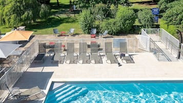 Una piscina al aire libre de temporada, sombrillas, tumbonas