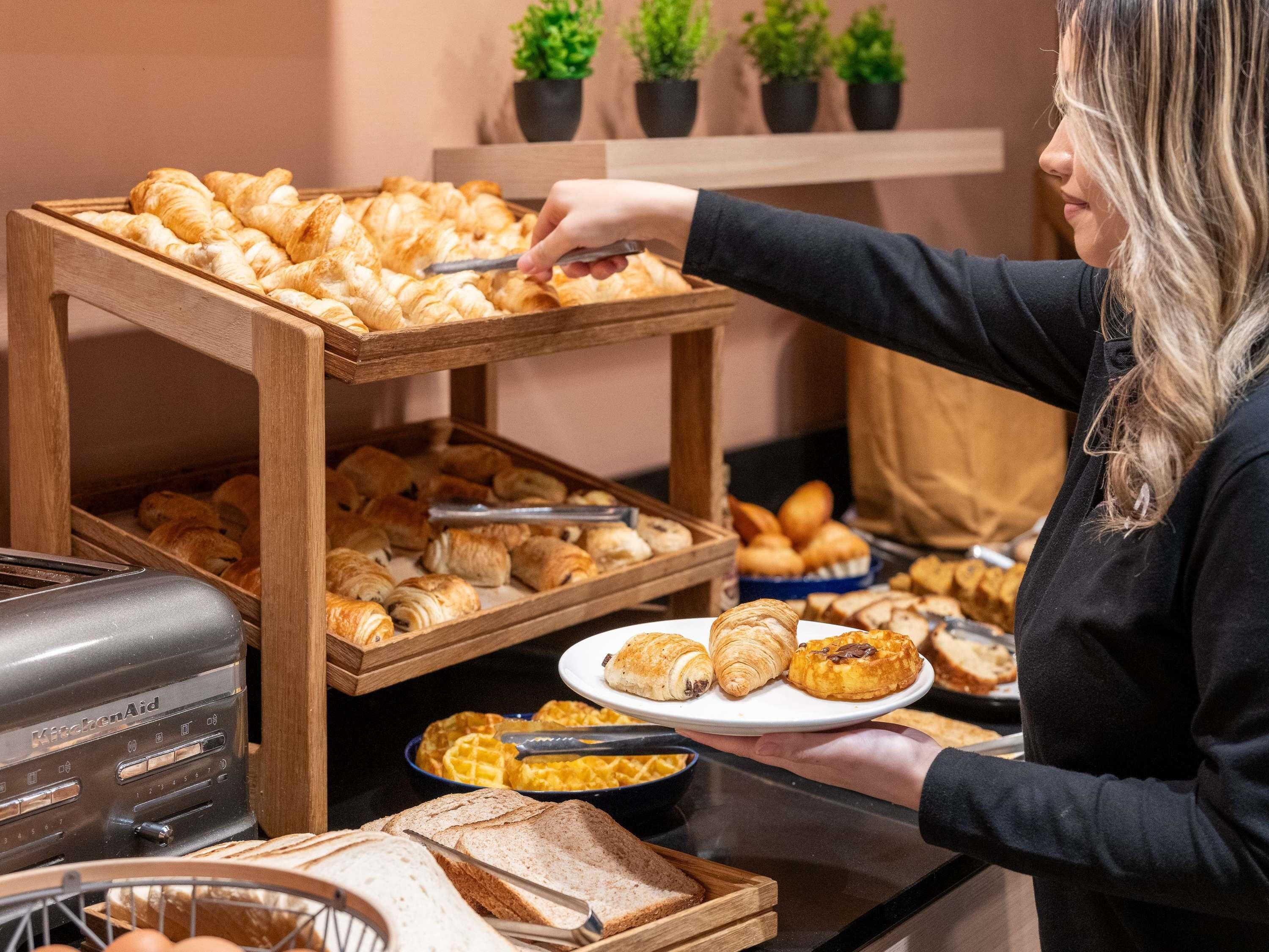 A buffet setup with various baked goods and a toaster.