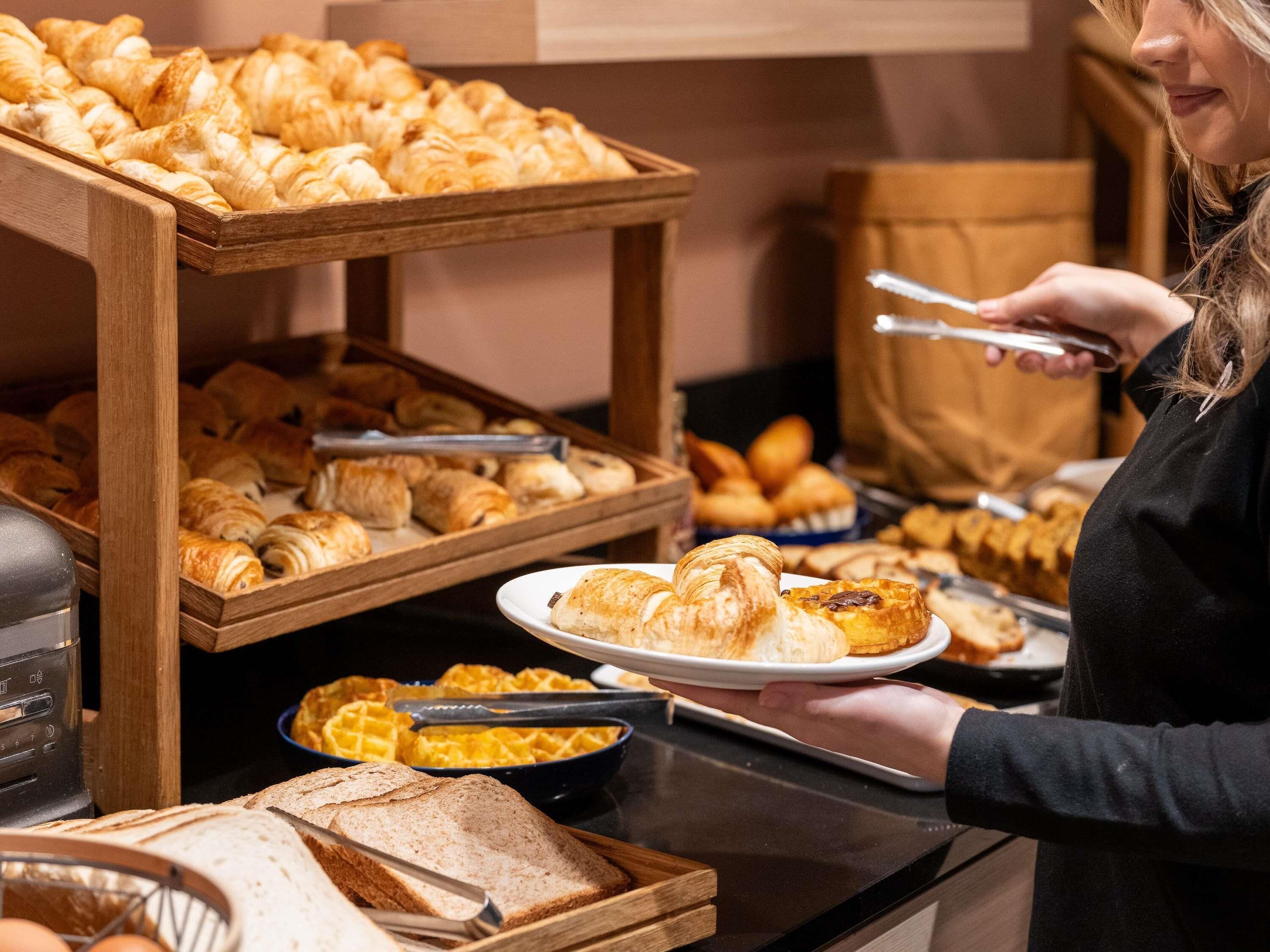 A buffet with various baked goods and bread.