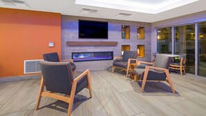 Een moderne lounge met een flatscreen televisie, een open haard en comfortabele zitplaatsen.