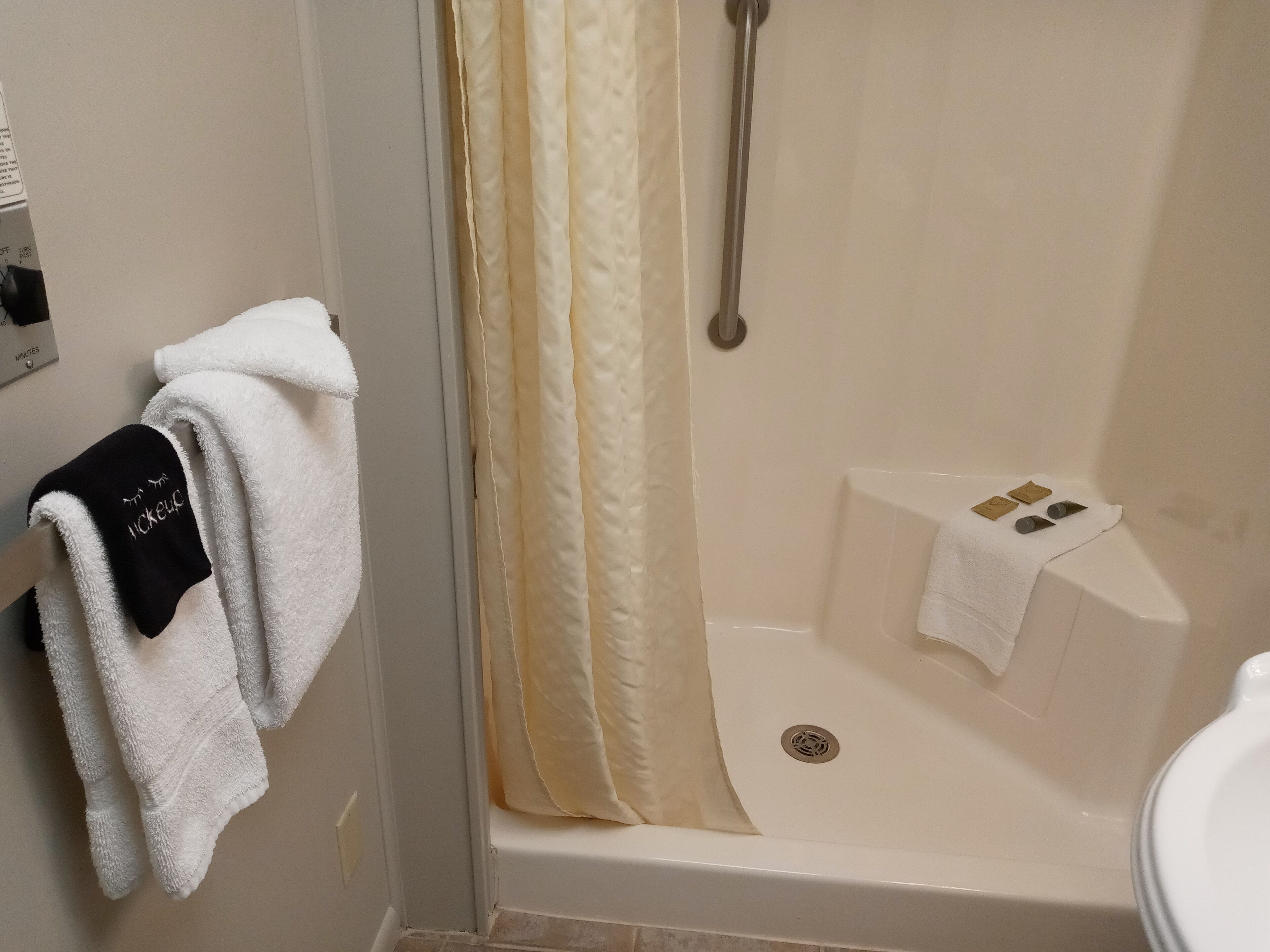 Ein Badezimmer mit einer Badewanne, einer Duschvorhang und einem Handtuchhalter mit Handtüchern.