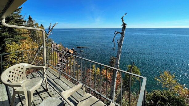 A balcony with a view of the sea, a chair, and a railing. - The Cliff Dweller on Lake Superior (Tofte)
