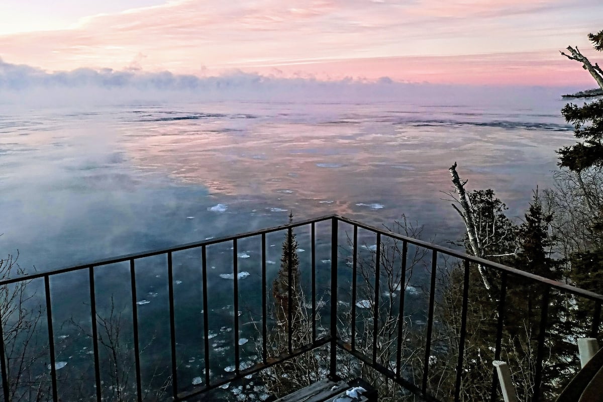 Ein weiter Panoramablick von einem Balkon über eine weite Landschaft, im Vordergrund eine Brüstung.