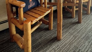 A wooden chair with a cushion, a table, a lamp, and a TV mounted on the wall. - The Cliff Dweller on Lake Superior (Tofte)
