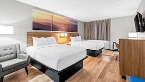 Quarto de hotel com duas camas, uma escrivaninha, uma cadeira e um quadro grande na parede.