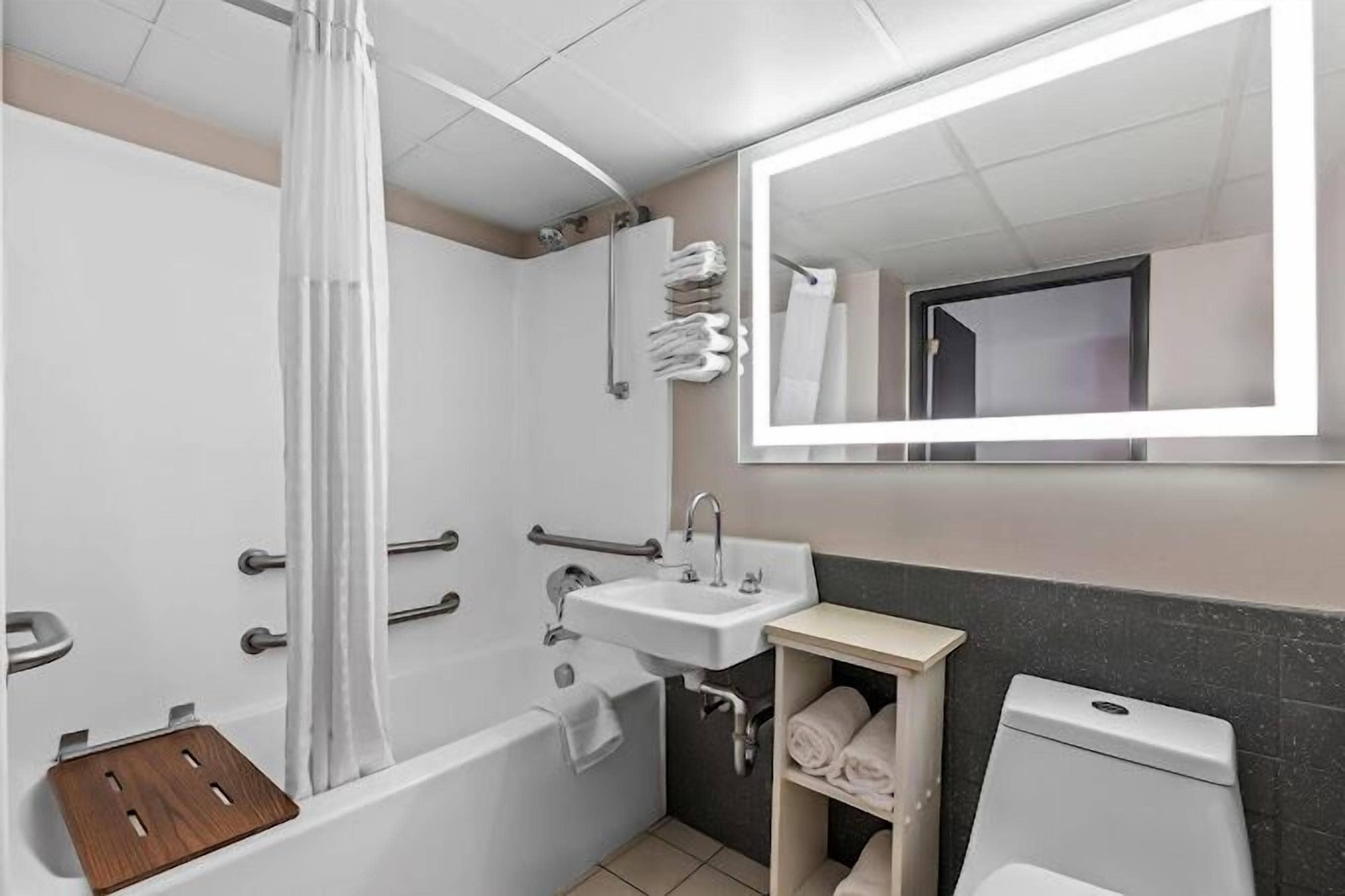 Une salle de bain avec une baignoire, un lavabo, des toilettes et un miroir.