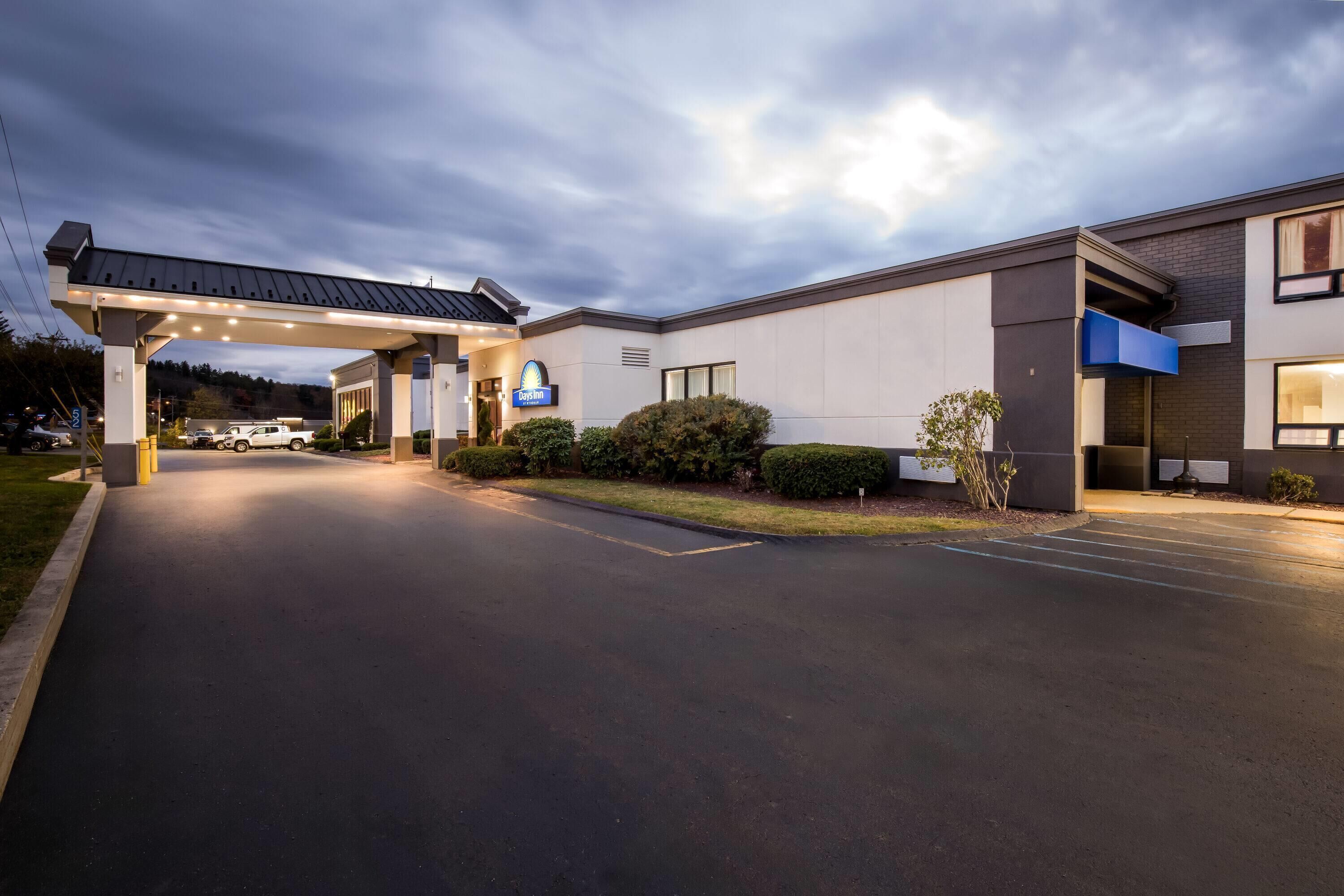 A hotel entrance with a covered driveway, a McDonald's sign, and a parking lot.
