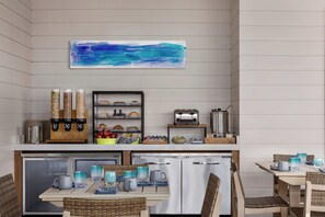 A compact kitchenette with a coffee machine, toaster, and storage shelves. - Holiday Inn Resort Jekyll Island by IHG (Jekyll Island)