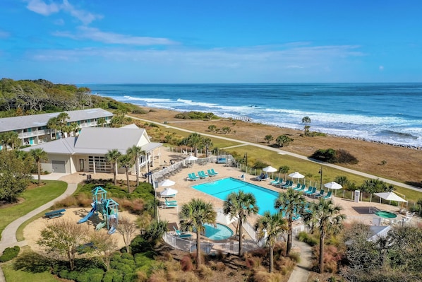 Resort com piscina, acesso à praia e área de recreação infantil.