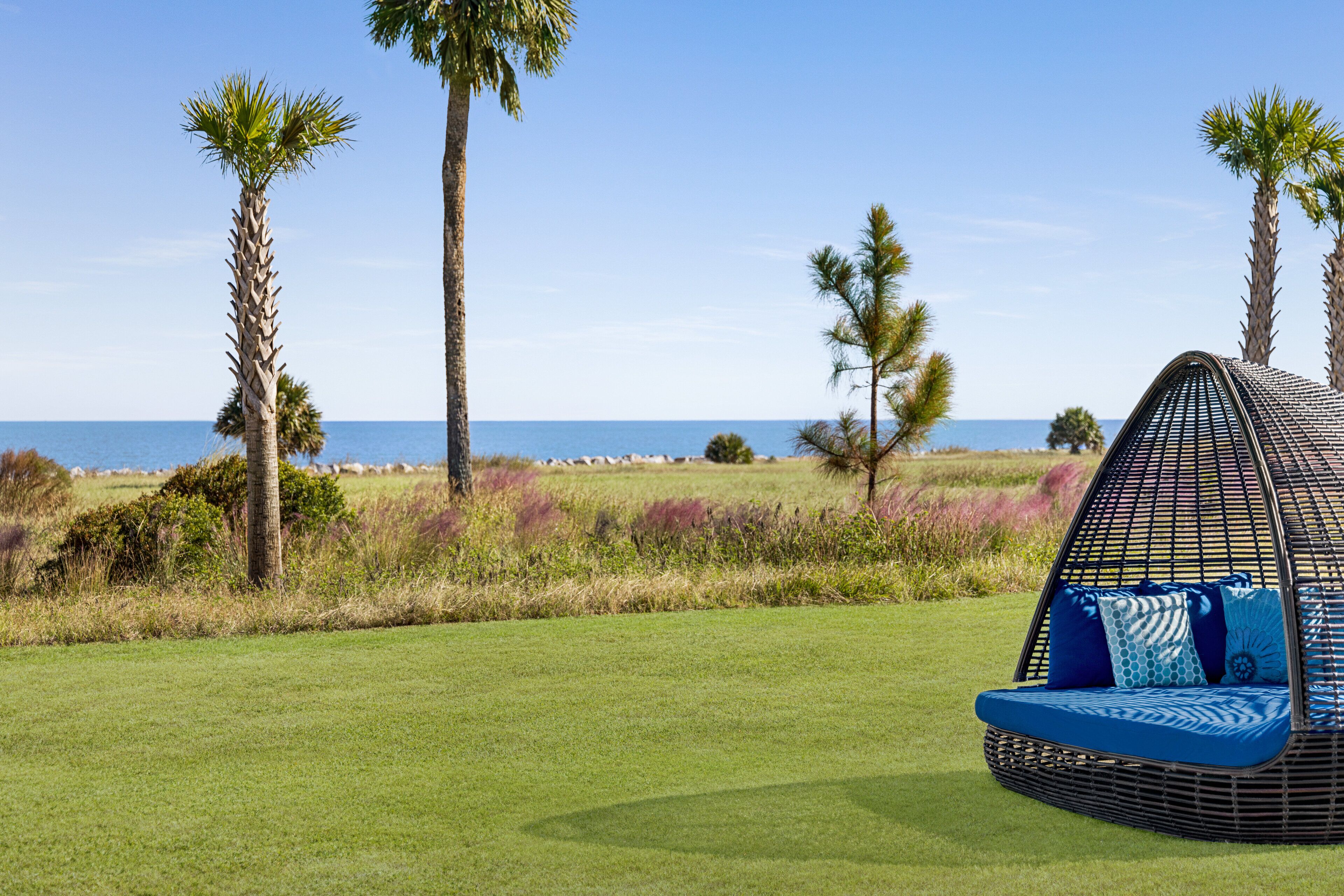 A beach view with a hanging chair and a view of the ocean.