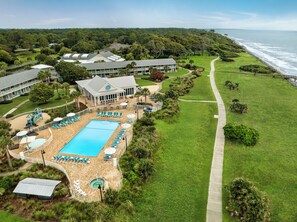 A resort with a large pool, sun loungers, and a view of the ocean. - Holiday Inn Resort Jekyll Island by IHG (Jekyll Island)