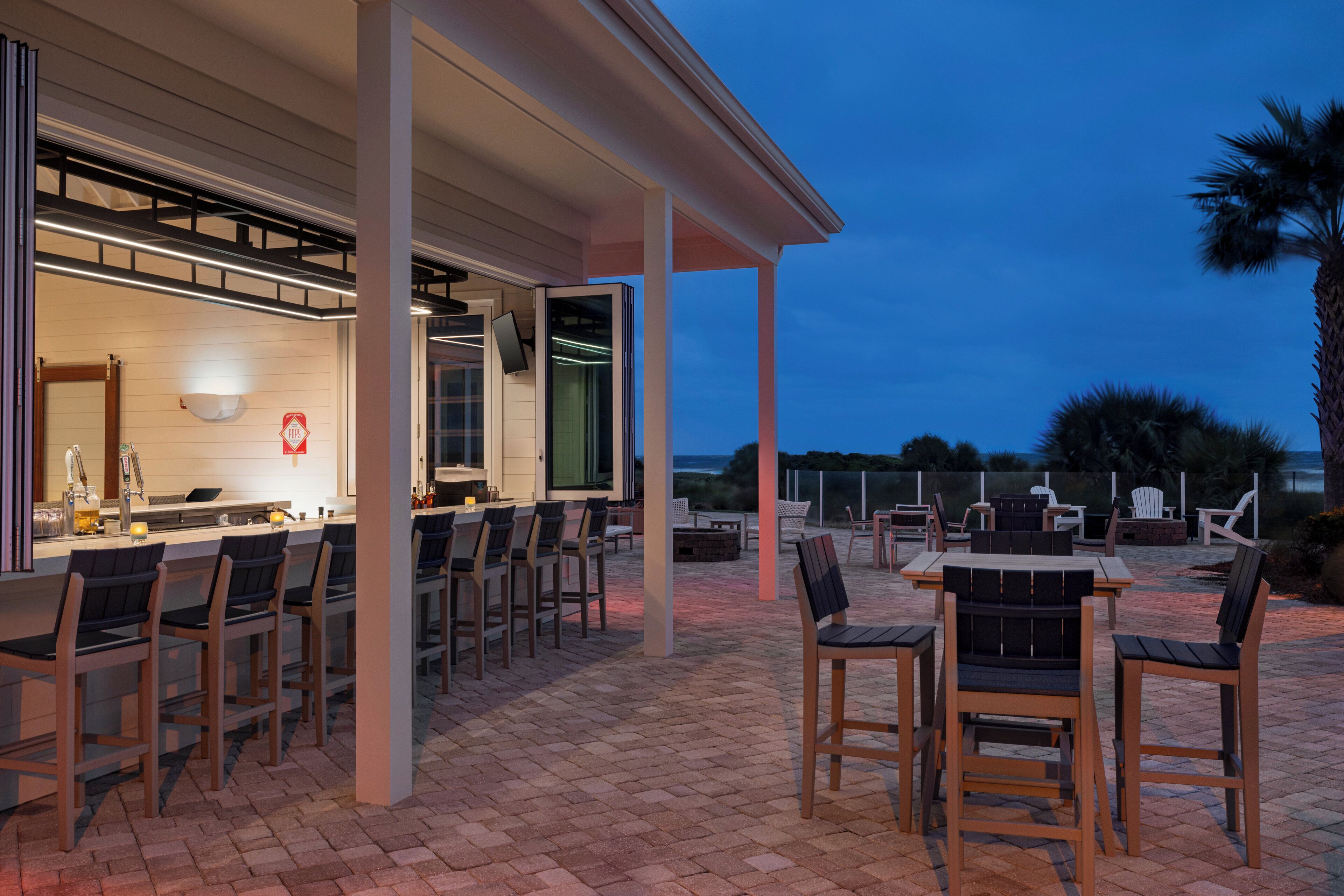 An outdoor patio with a bar area, seating, and a view of the landscape.