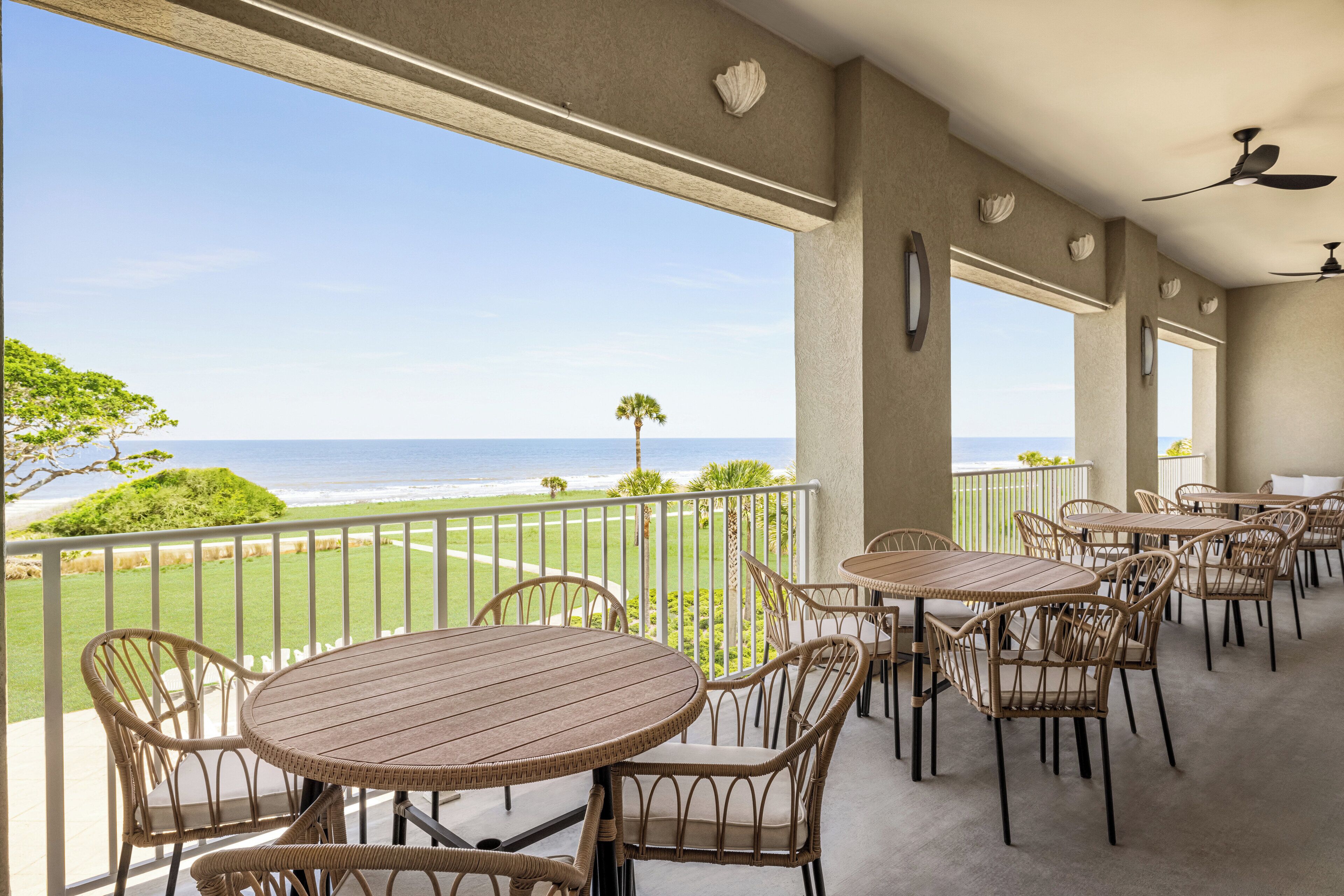 A balcony with wicker furniture and a view of the ocean.