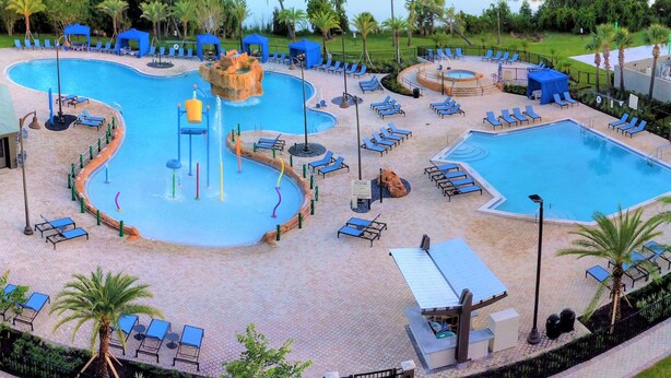 A large outdoor swimming pool with multiple lanes, surrounded by lounge chairs and umbrellas. - Wyndham Lake Buena Vista – Disney Springs® Area (Lake Buena Vista)