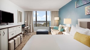 A hotel room with a bed, a desk, a television, and a large window with a city view. - Wyndham Lake Buena Vista – Disney Springs® Area (Lake Buena Vista)