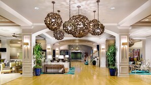 A spacious lobby with a wooden floor, large decorative chandeliers, and potted plants. - Wyndham Lake Buena Vista – Disney Springs® Area (Lake Buena Vista)