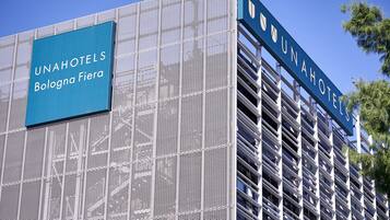 Un edificio con un cartello che riporta la scritta "UNAHOTELS Bologna Fiera".
