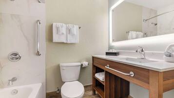 A modern bathroom with a bathtub, toilet, and shower.