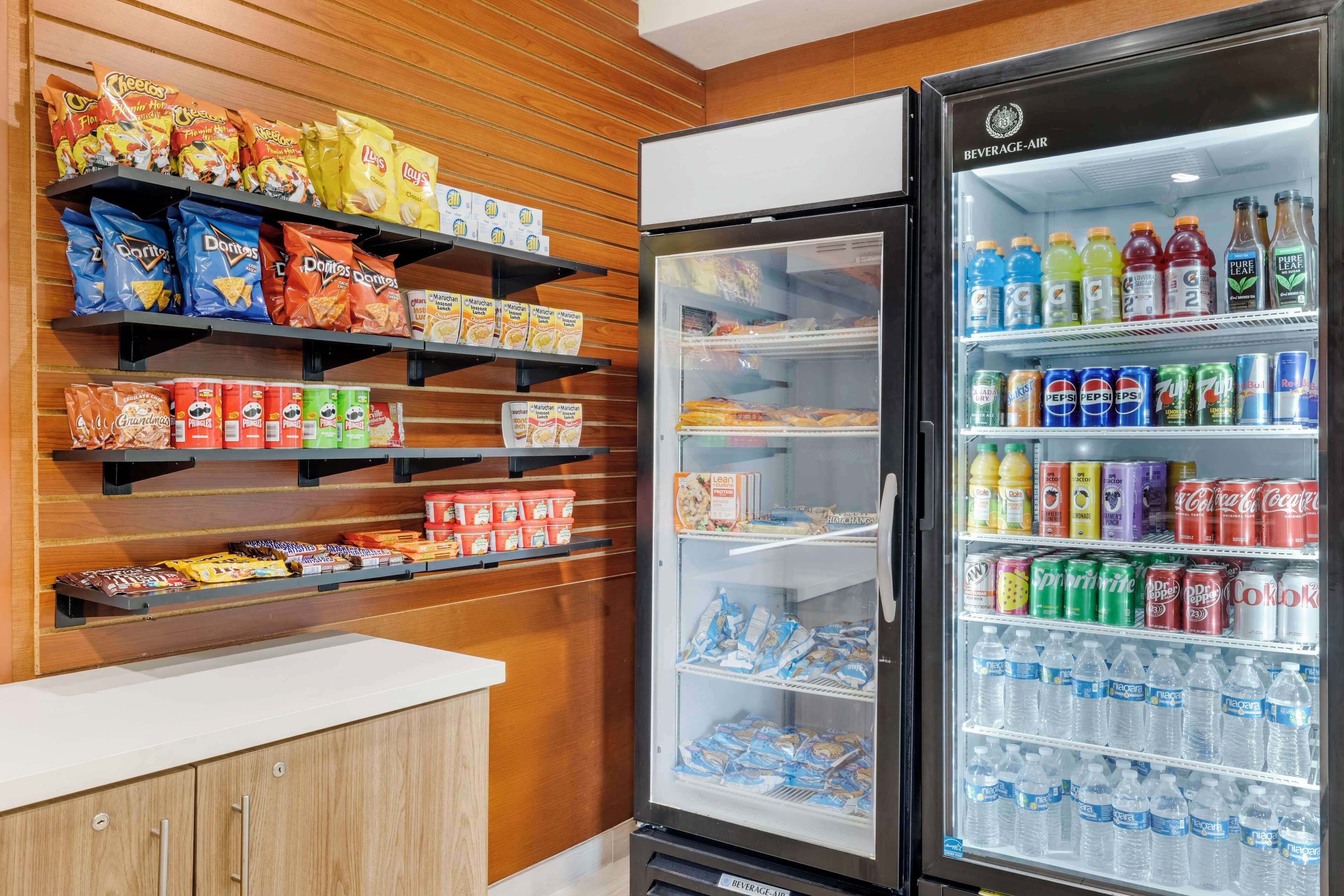 A vending machine stocked with snacks and beverages, including chips, cookies, and sodas.