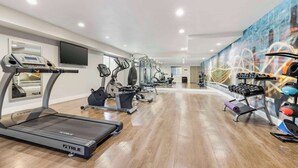 A modern gym with treadmills, elliptical machines, and weightlifting equipment.