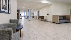 A spacious lobby with a modern design, featuring a seating area with sofas and armchairs, a reception desk, and a clear pathway leading to other areas. - Holiday Inn Express Augusta Downtown by IHG (Augusta)