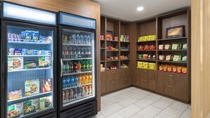 A refrigerated display case with various food items and a beverage dispenser. - Holiday Inn Express Augusta Downtown by IHG (Augusta)