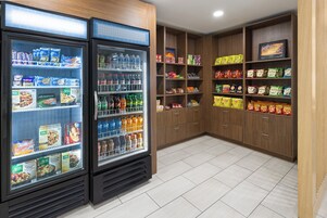 Un enfriador refrigerado con diversos alimentos y un dispensador de bebidas.