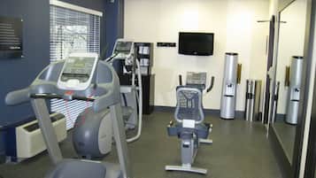 A fitness center with treadmills, a stationary bike, and a mirrored wall.
