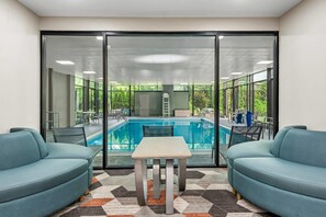 A room with a pool, two sofas, a table, and a patterned rug. - Comfort Inn Largo-Washington DC East (Upper Marlboro)