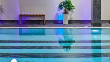 A swimming pool with a bench and potted plants.