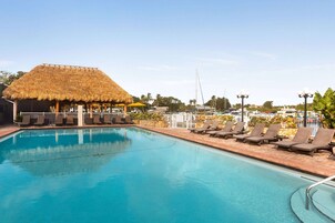 Una piscina al aire libre, sombrillas, sillones reclinables de piscina