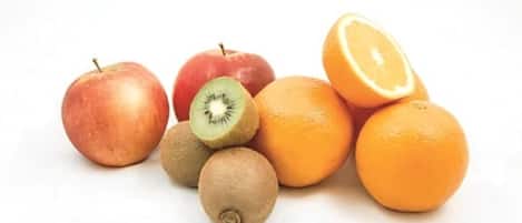 Diversa variedad de frutas, incluyendo manzanas, kiwis, naranjas y media naranja.