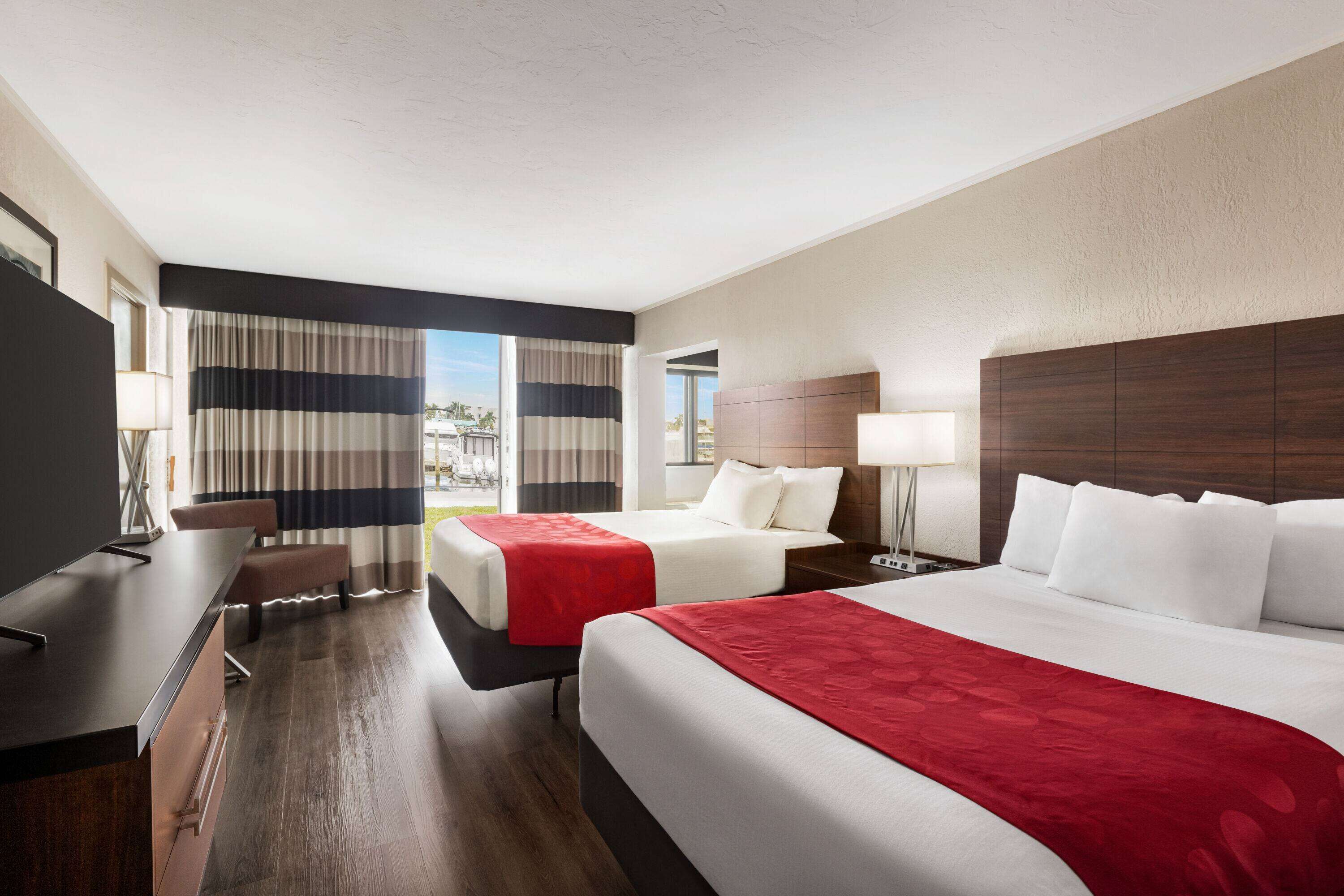 Ein Hotelzimmer mit zwei Betten, einem Schreibtisch und einem Sessel.