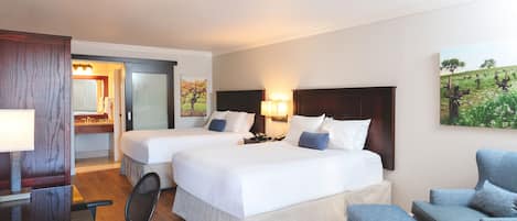 Een hotelkamer met twee bedden, een bureau, een stoel en een bank.
