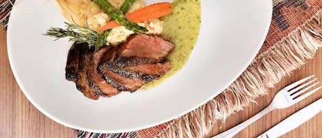 Un plato de comida con filete, zanahorias, espárragos y puré de papas.
