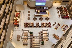 A spacious indoor area with multiple seating arrangements, a bar, and a television screen.