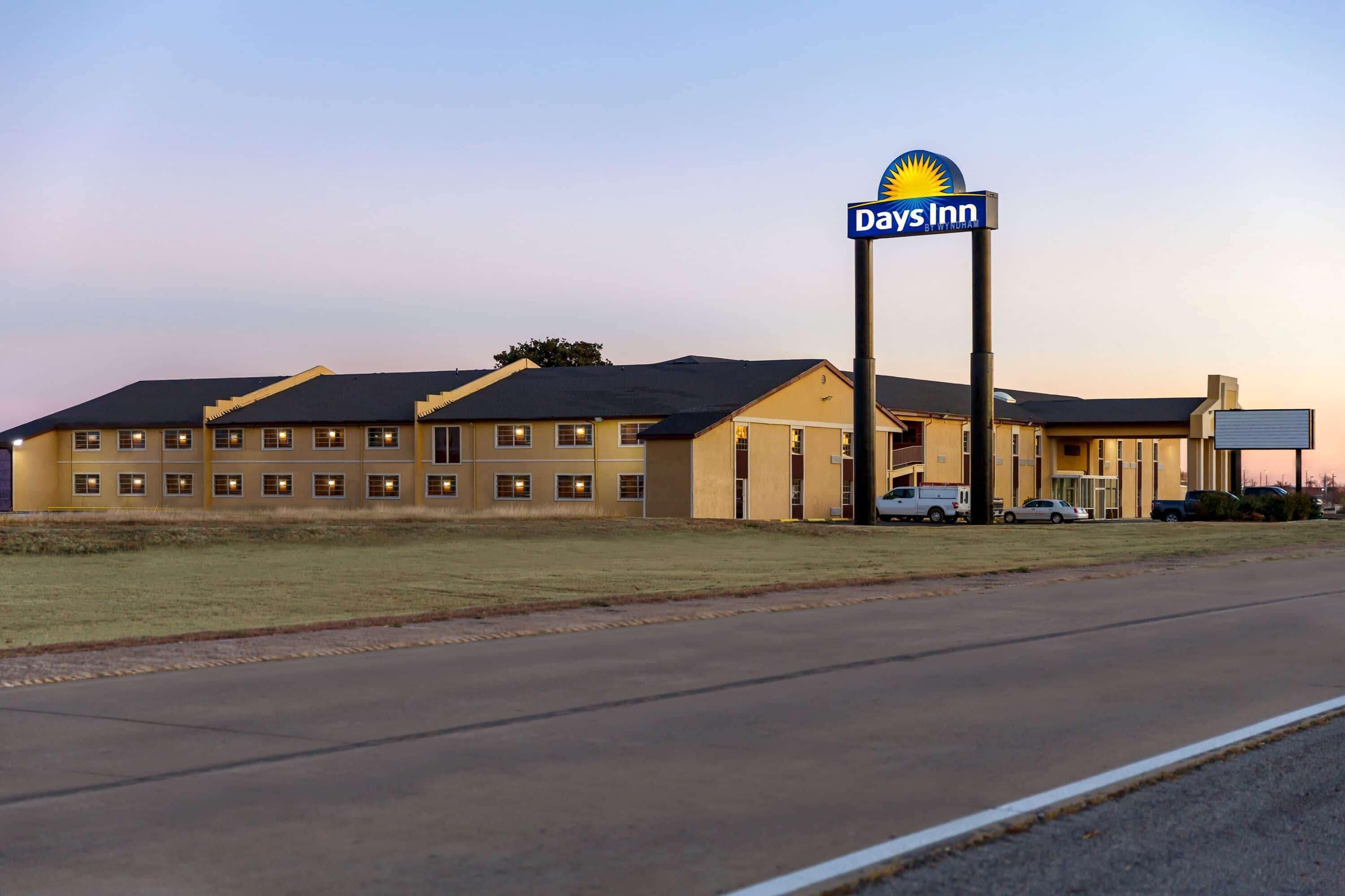 A Days Inn hotel with a large sign, multiple windows, and a parking lot.