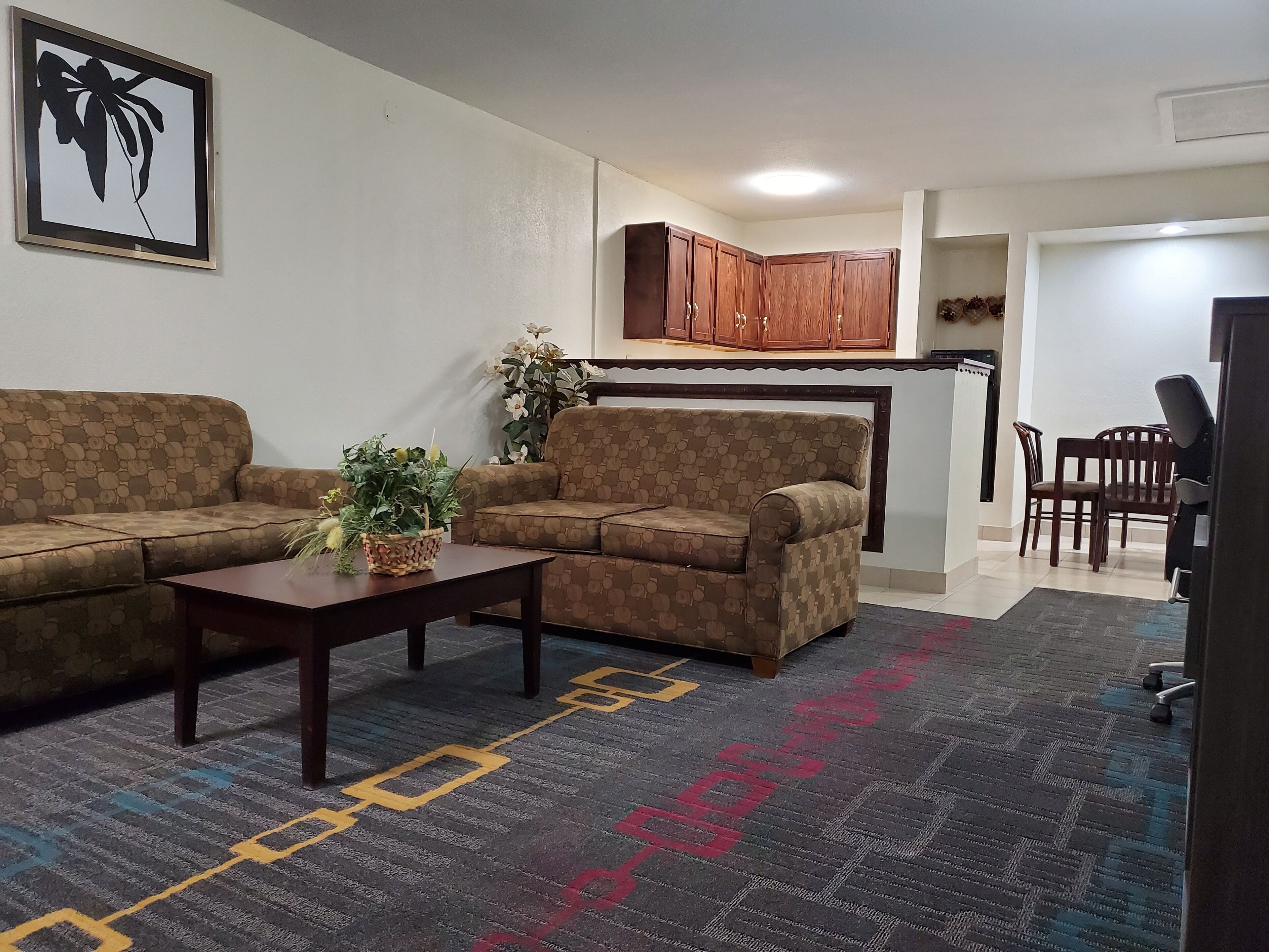 Ein Wohnzimmer mit einer Couch, einem Couchtisch und einem Teppich mit Muster.