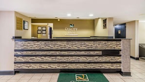 A reception desk with a logo for Quality Inn by Choice Hotels.