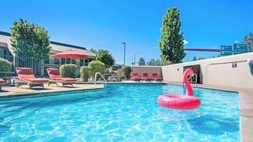 Una piscina al aire libre de temporada, tumbonas