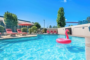 Una piscina al aire libre de temporada, tumbonas