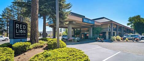 A Red Lion Inn & Suites with a covered outdoor area, parking lot, and well-maintained landscaping.