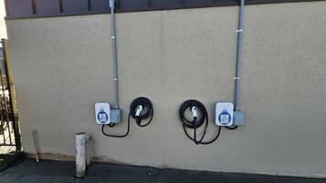 Parede com dois compartimentos elétricos e um cabo enrolado.