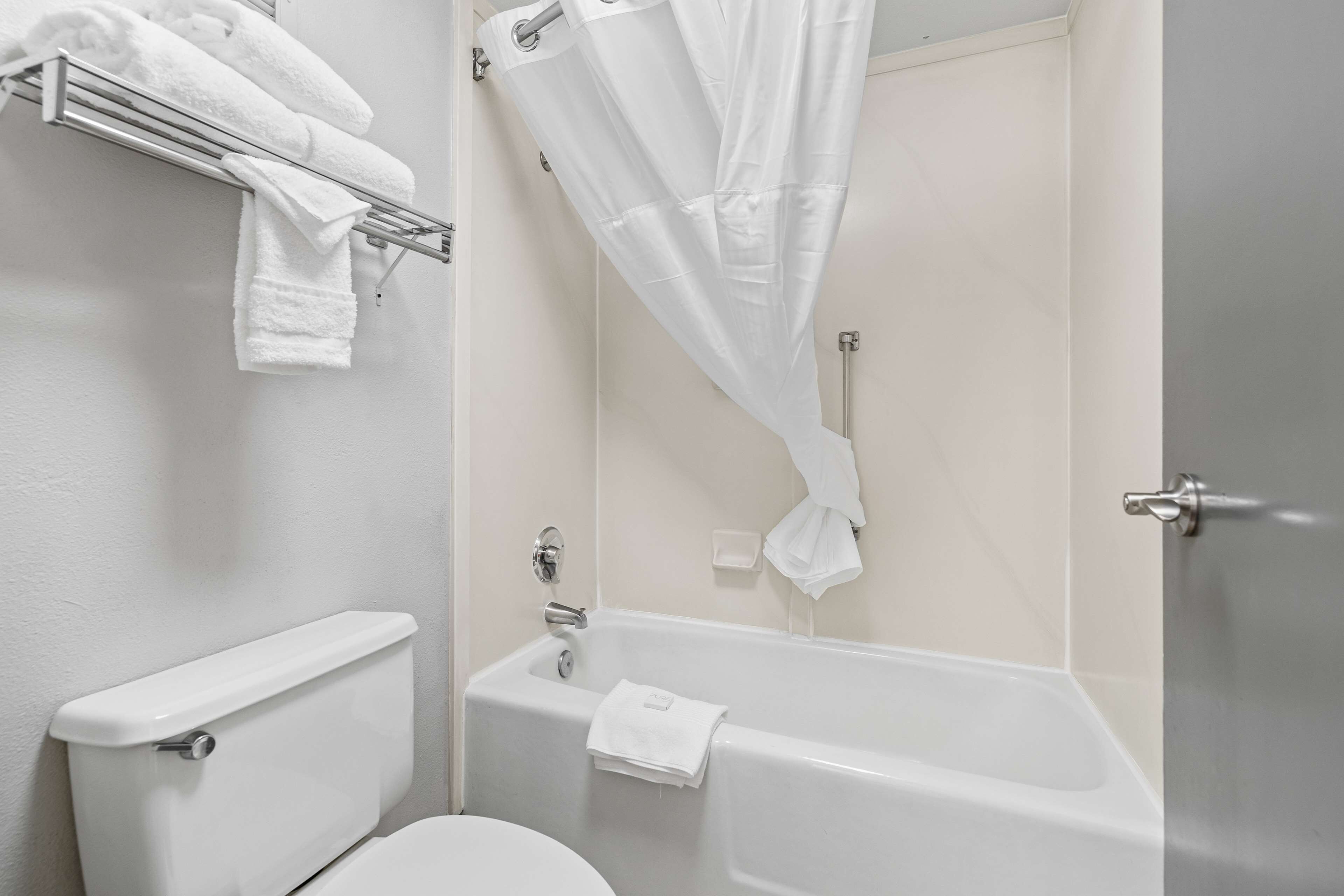 Un baño con inodoro, bañera y cortina de ducha.