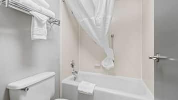 A bathroom with a toilet, a bathtub, and a shower curtain.