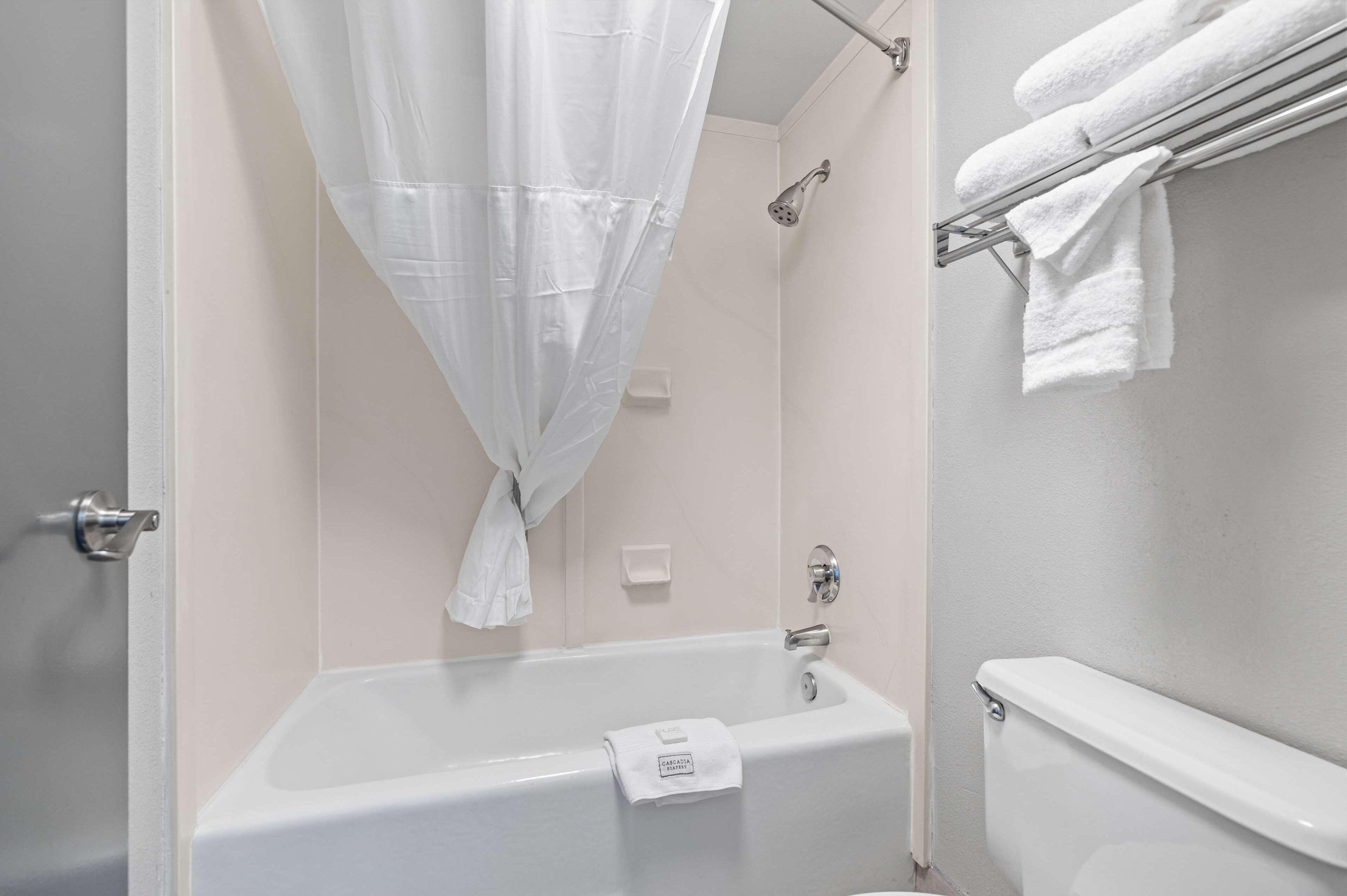 A bathroom with a bathtub, a shower, and a towel rack.