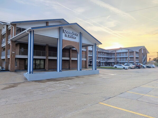 Ein Days Inn & Suites mit überdachter Eingangsparte, mehreren Balkonen und einem Parkplatz.