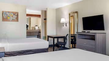 A hotel room with two beds, a desk, a chair, a television, and a mirror.